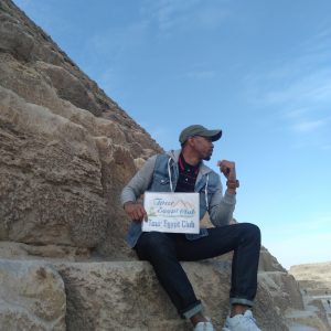 A tourist sitting in awe before the majestic Great Pyramid of Giza