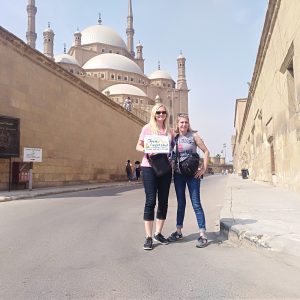 Friends laughing and posing in front of the historic structures of Salah al-Din Citadel in Cairo
