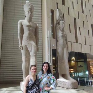 Friends admiring ancient Egyptian artifacts together within the Grand Egyptian Museum's spacious halls